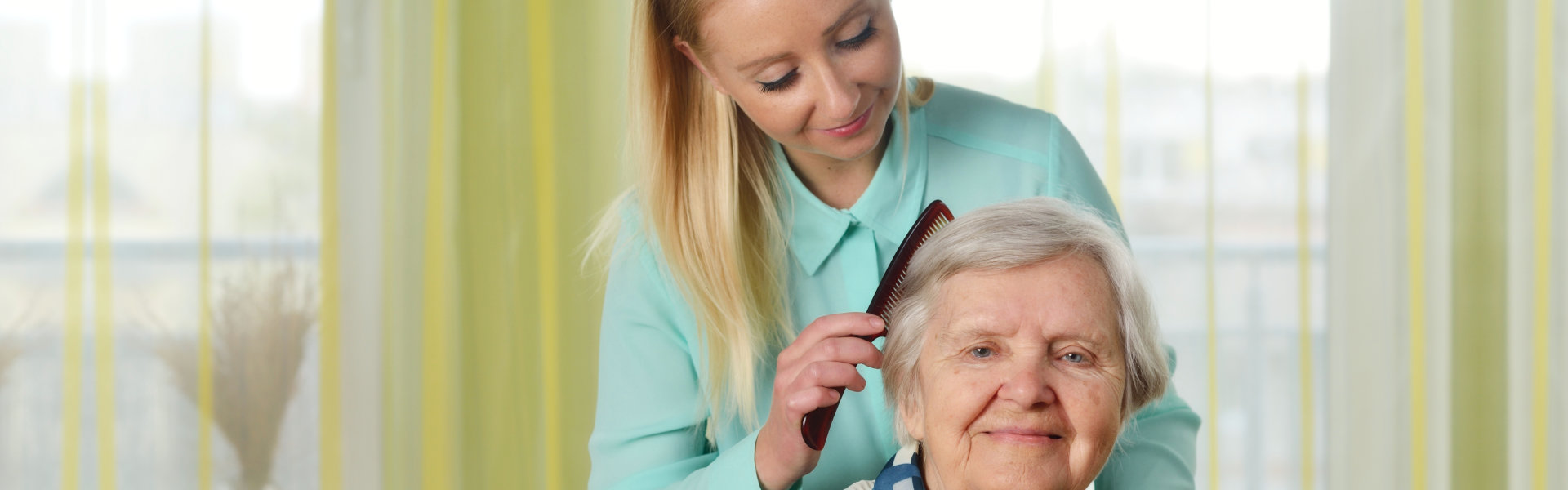 caregiver brushing the hair of the senior